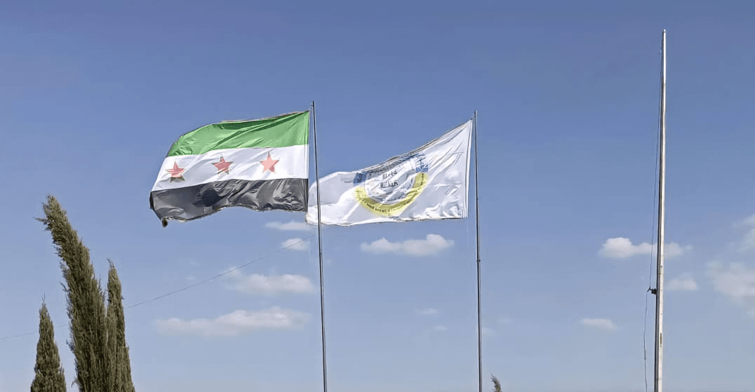 بۆ یەکەمجار بەڕێوەبەرایەتیی خۆسەر ئاڵای سووریا لەپاڵ دروشمەکەی بەرز دەکاتەوە